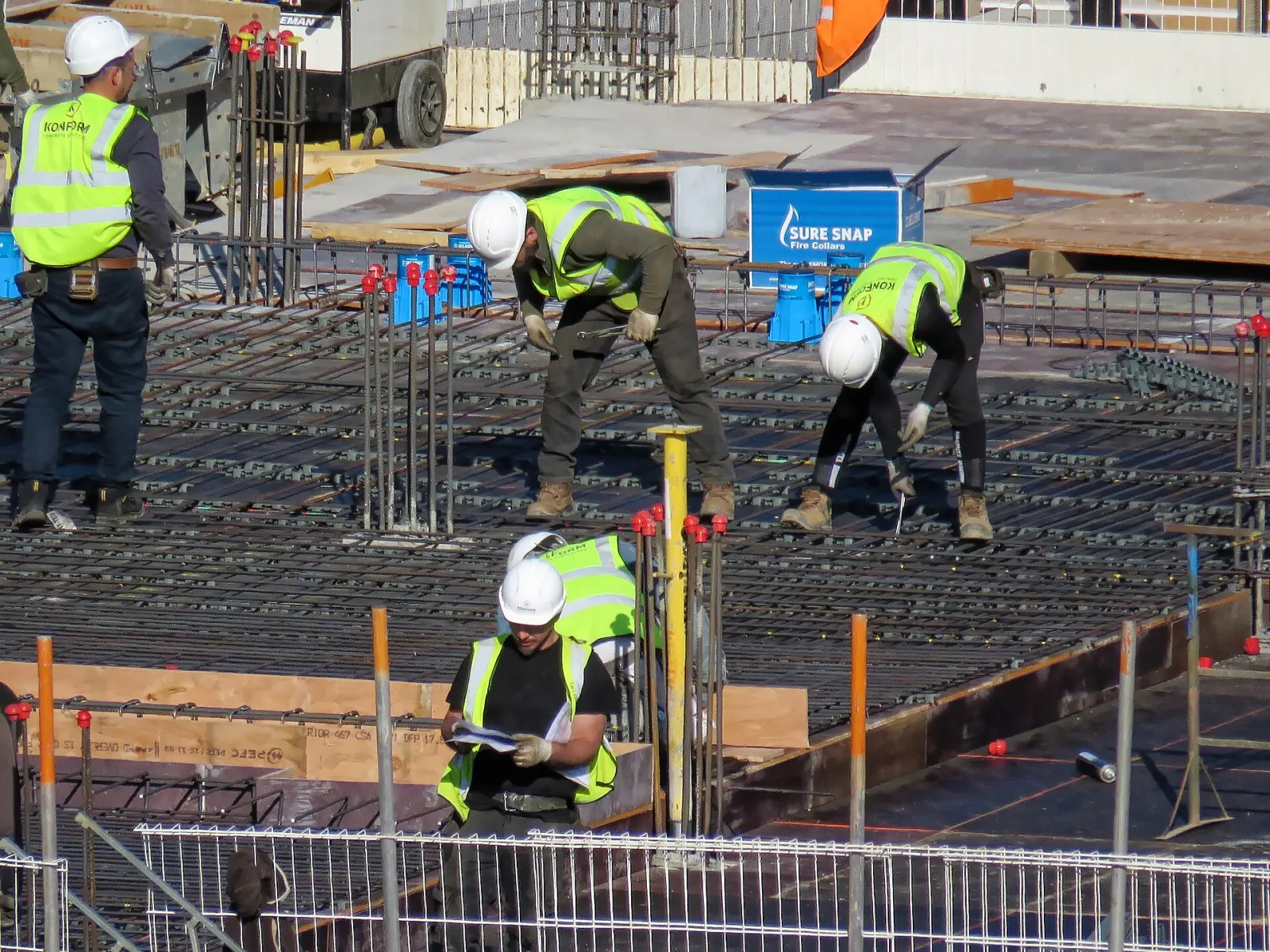Construction workers placing rebar on a building site