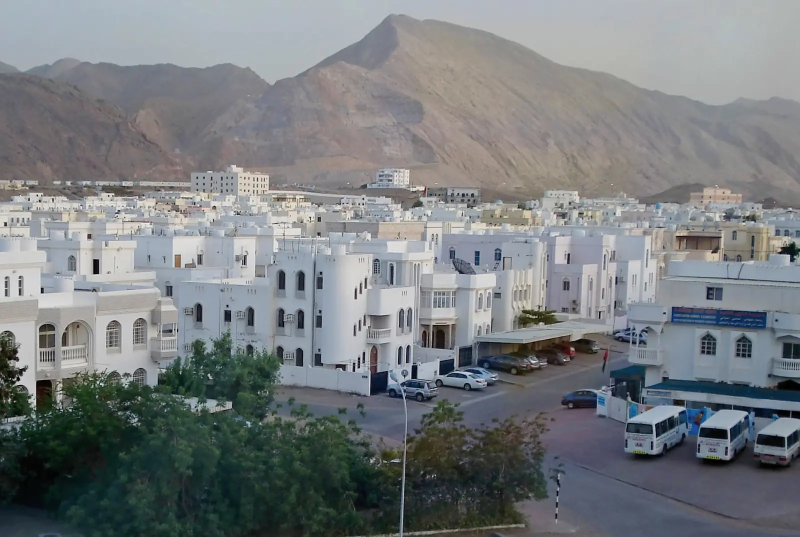 White residential buildings in Muscat beneath the mountains