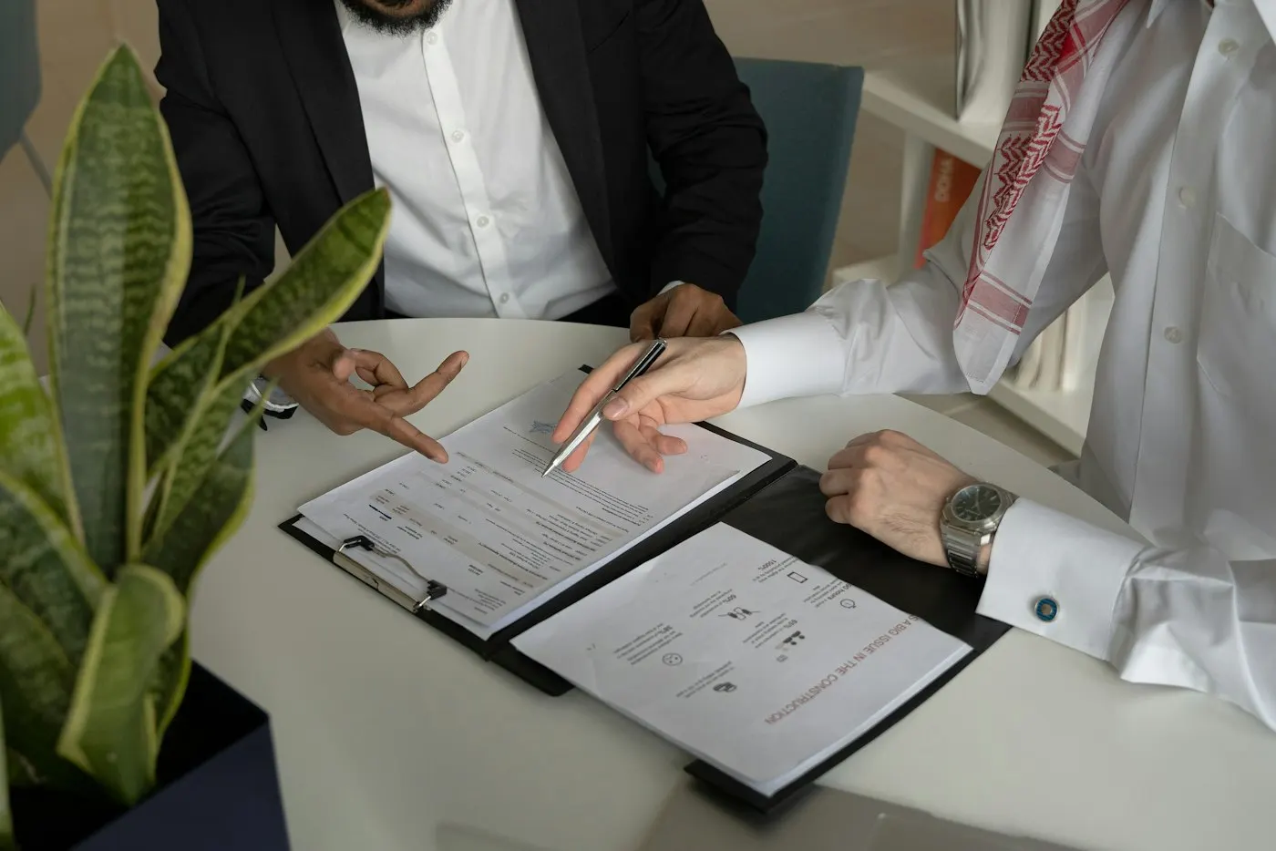 Two business partners reviewing a contract at a table